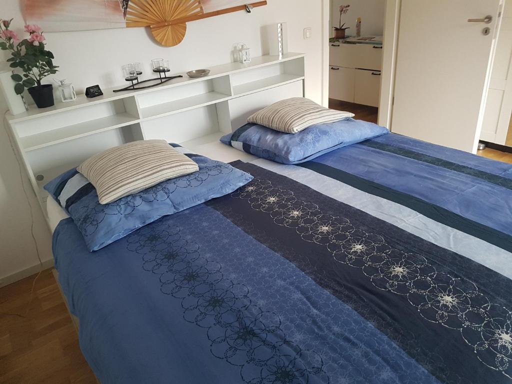 2 Betten in einem Zimmer mit blauer Bettwäsche und Kissen in der Unterkunft Zimmer mit eigenem Bad in Märchenstadt! in Heidelberg