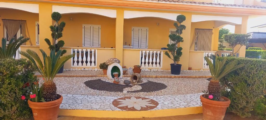a house with a fountain in the middle of a courtyard at Villettemire in Capo Vaticano