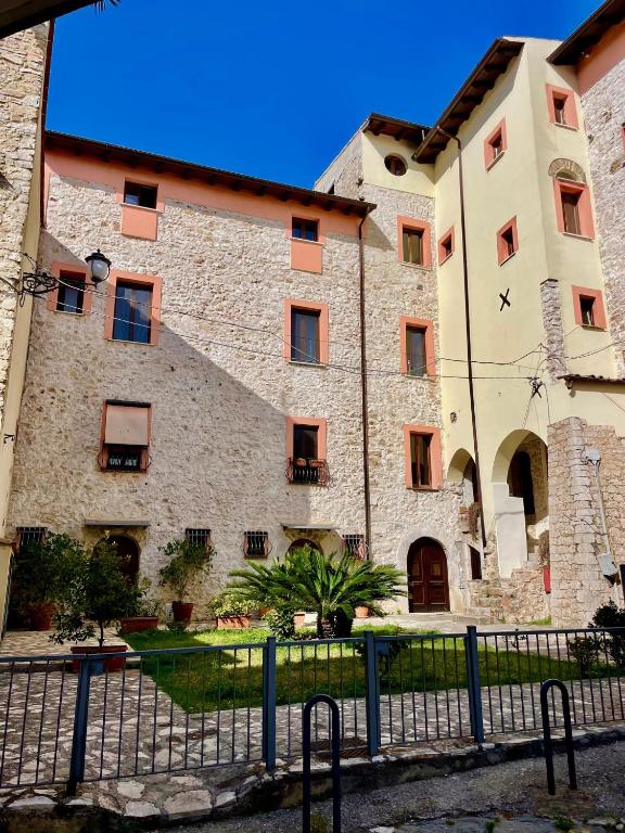 a large stone building with a fence in front of it at AL CARDINALE in Fondi