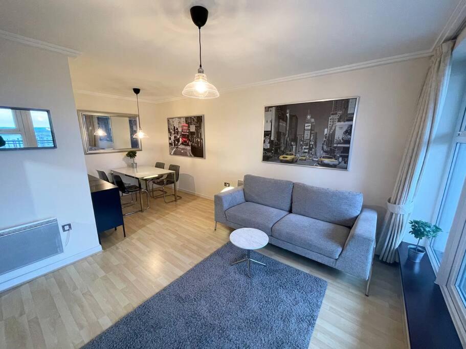 a living room with a couch and a table at LUXURY APARTMENT, SAUNA, GYM, 24hrs Concierge in Woking