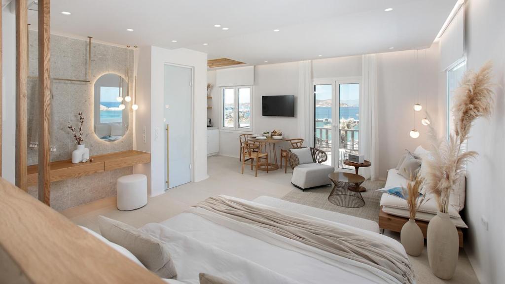 una camera con un grande letto e una sala da pranzo di Porta Marina a Naxos Chora