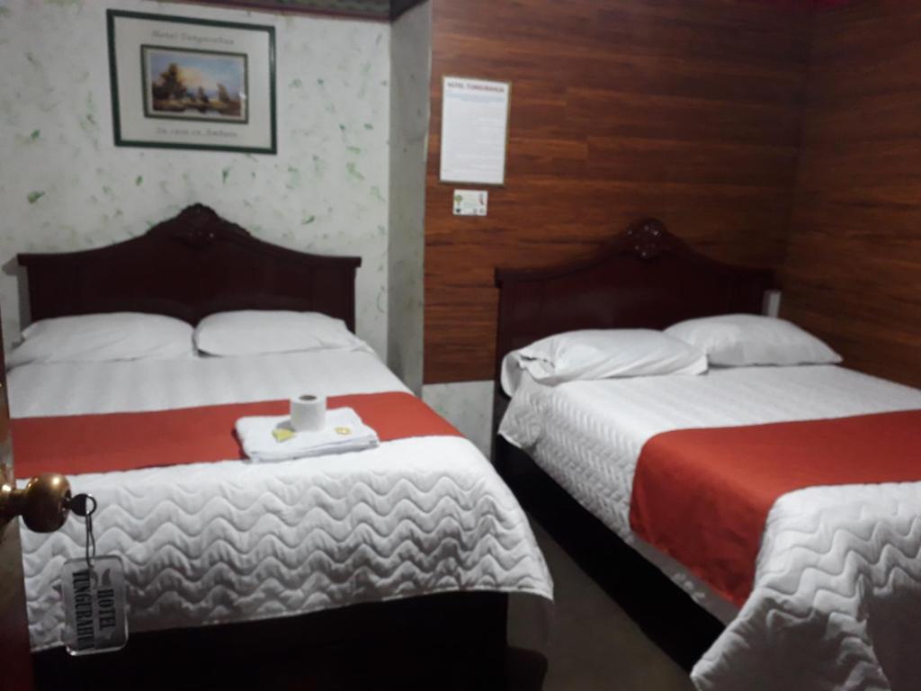 a hotel room with two beds in a room at Hotel Tungurahua in Ambato