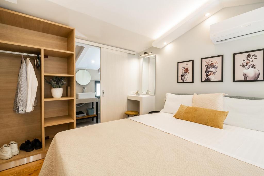 1 dormitorio con 1 cama blanca grande y estanterías de madera en Bright & elegant loft suite in the city center, en Zakynthos