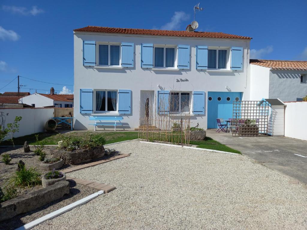 a white house with blue windows and a driveway at Les Crevettes in LʼÉpine