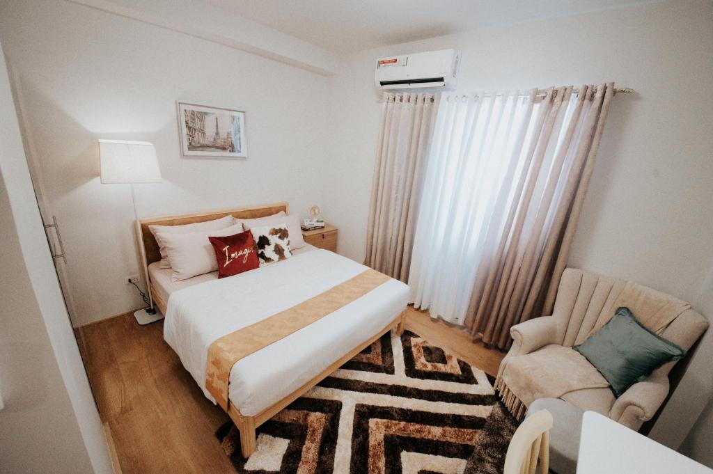 1 dormitorio pequeño con 1 cama y 1 silla en LFCM Condo Home @ Mesatierra Residences Davao City en Davao