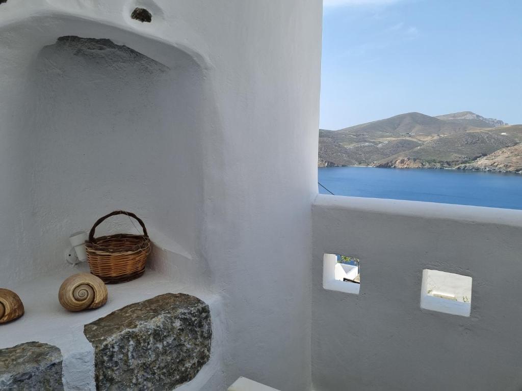 a white room with a basket and a view of the ocean at Nikola's place II in Astypalaia Town
