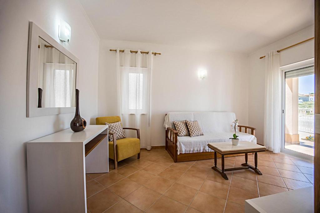 een woonkamer met een bank en een tafel bij Casa Bege T2 in Burgau