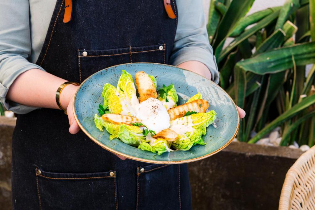 a person holding a plate of salad and seafood at InterContinental Muscat by IHG in Muscat
