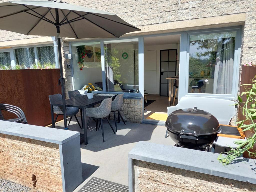 d'une terrasse avec un grill, une table et des chaises. dans l'établissement Au Studio 339 des Terrasses de Malmedy, à Malmedy