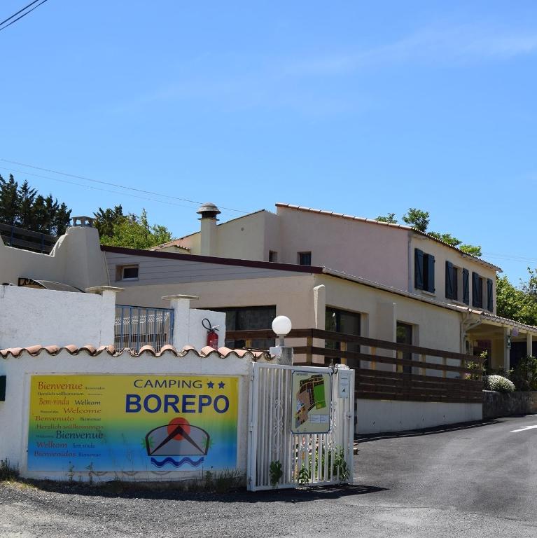 une maison avec une clôture devant dans l'établissement Camping Borepo, à Villeveyrac