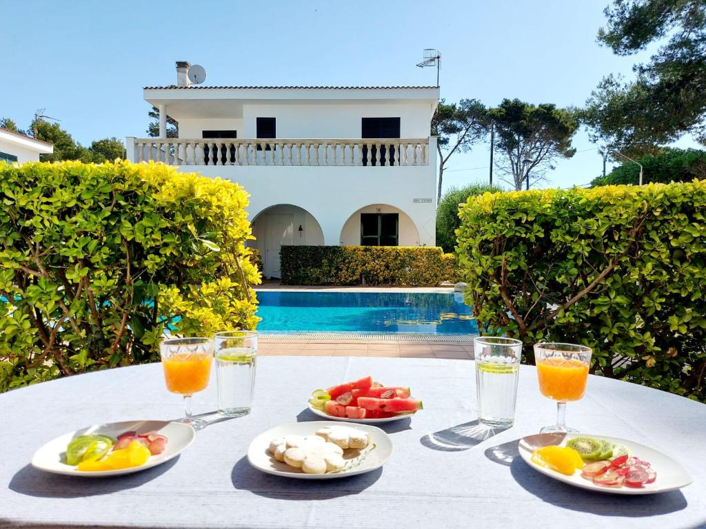 uma mesa com pratos de fruta e copos de sumo de laranja em Villa Limón em Cala Blanca