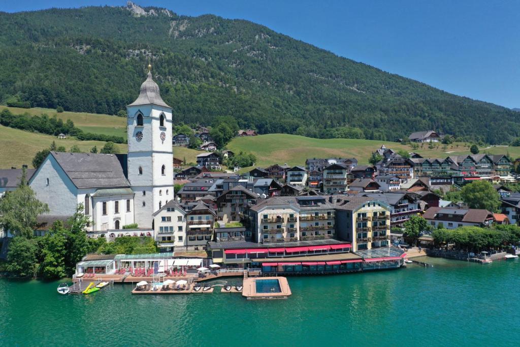 a town on the water with a clock tower at Romantik Hotel Im Weissen Rössl am Wolfgangsee in St. Wolfgang