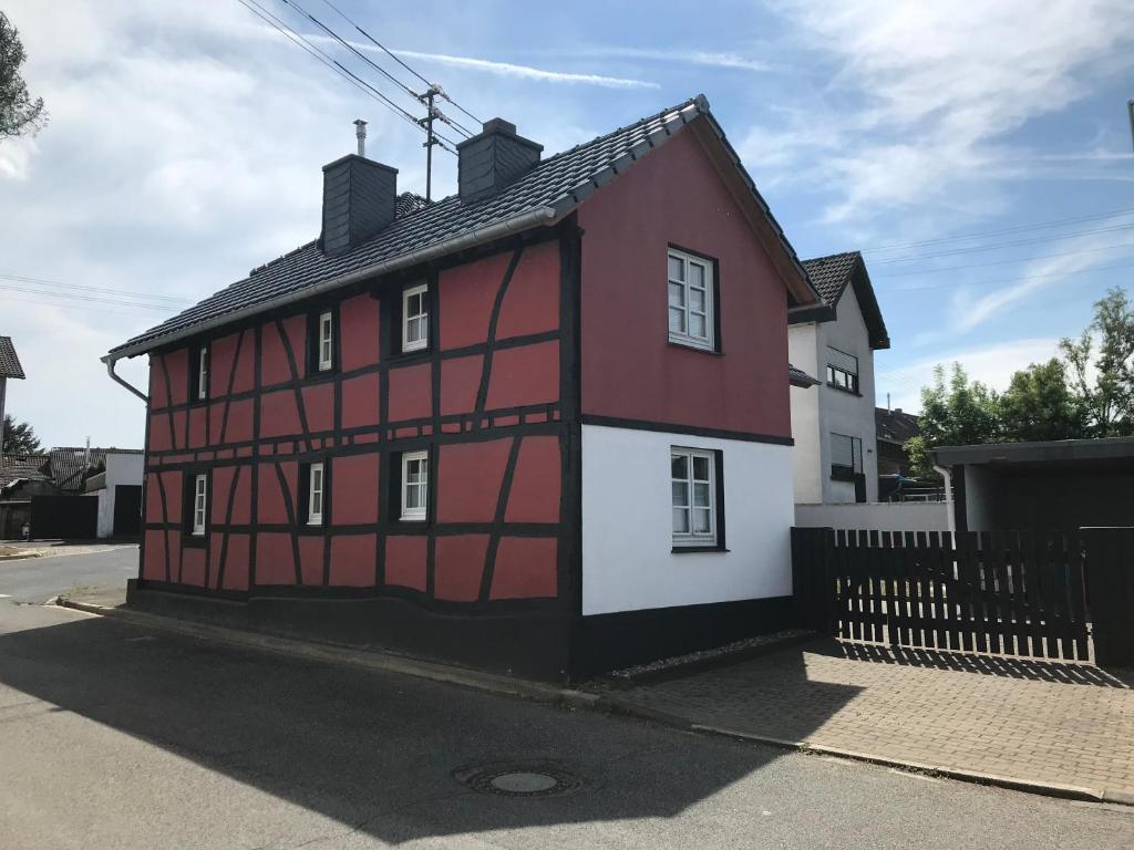 a red and white building on the side of a street at Ferienhaus Eifeldömchen in Bad Münstereifel