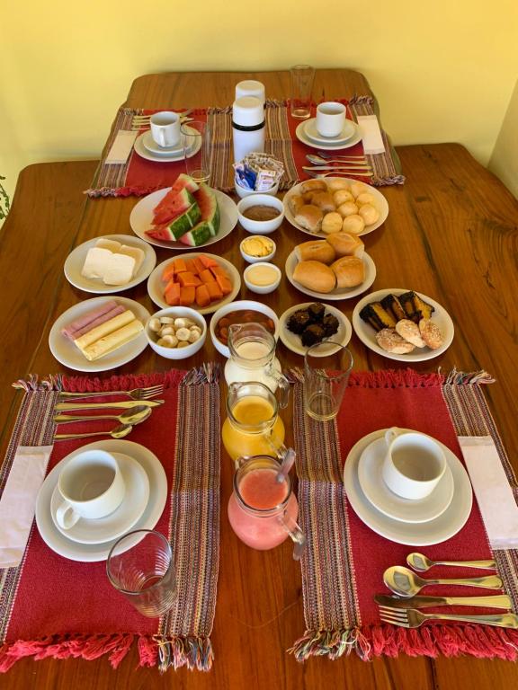una mesa con platos de comida y bebidas. en Pousada Portal do Cerrado, en Pirenópolis