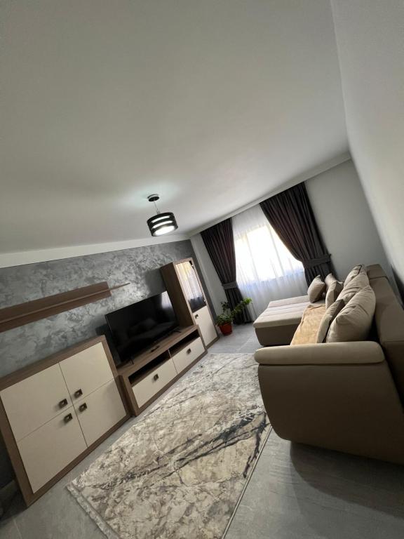 a living room with a couch and a tv at Borșa ApartHotel 4 in Borşa