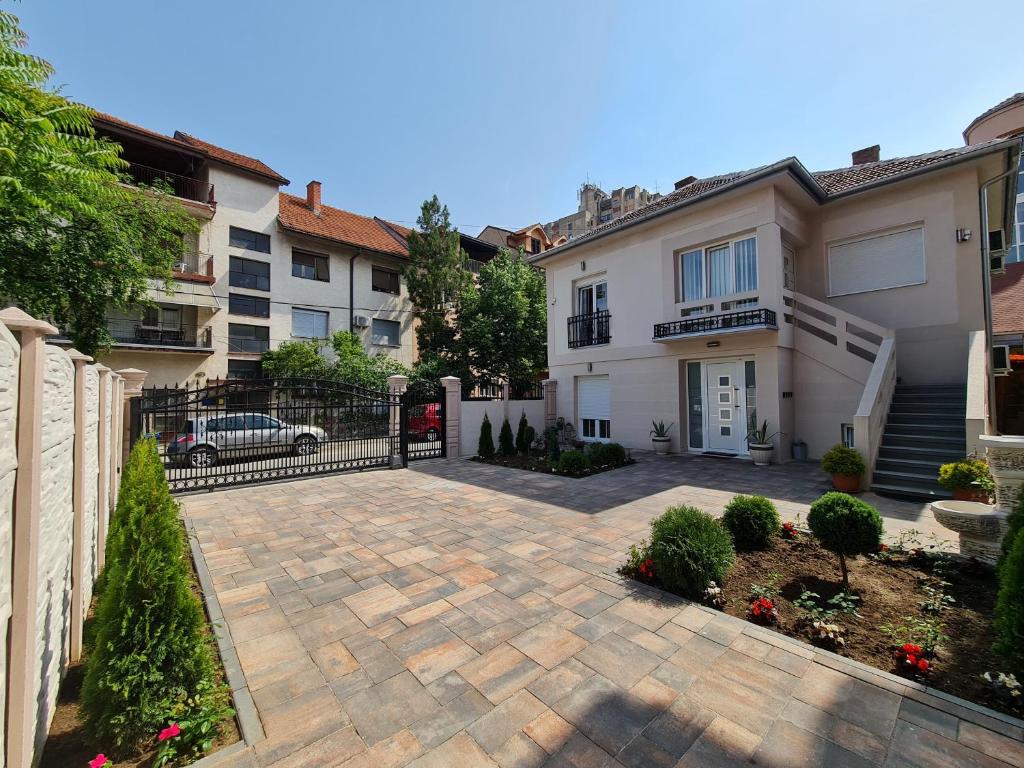 a house with a paver driveway in a yard at "Astor16" Apartments in Niš