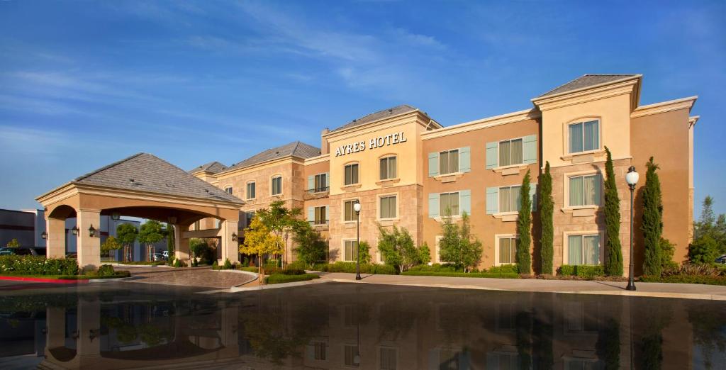 a hotel building with a pool in front of it at Ayres Hotel Chino Hills - Ontario in Chino Hills