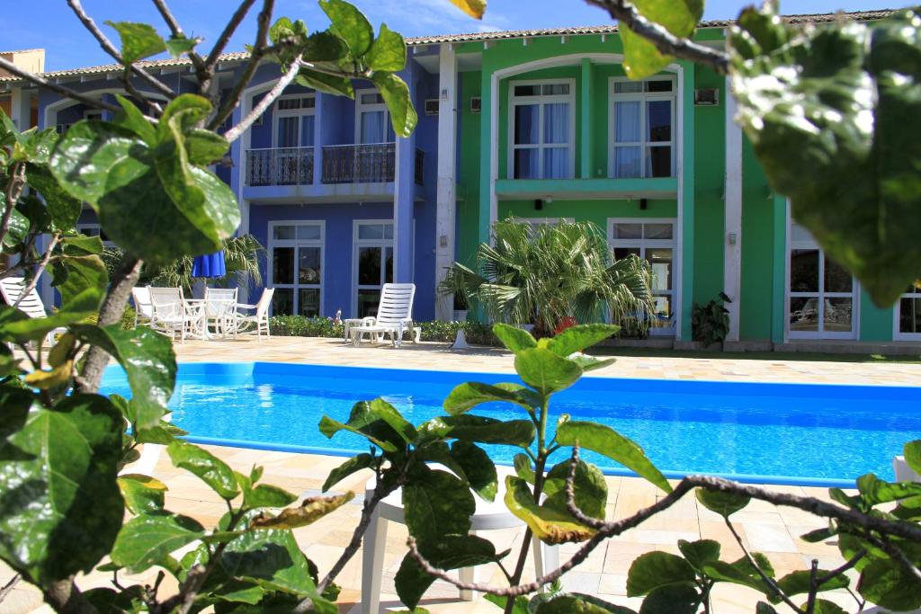 a house with a swimming pool in front of it at Hotel Porto de Paz - Shantiniketan in São Francisco do Sul