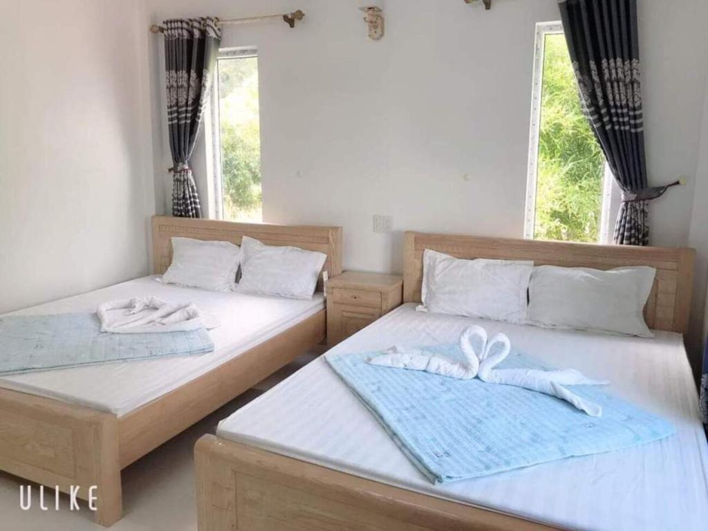 廣寧省的住宿－Song Châu Villa Quan Lạn，配有两张床的房间的两张床