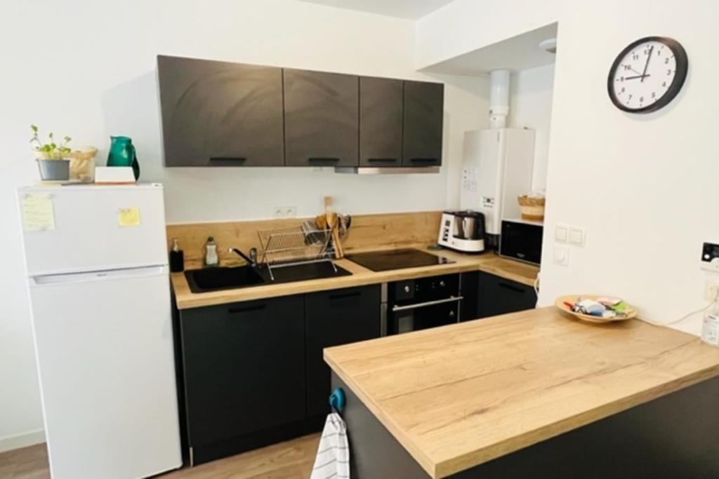 Il comprend une cuisine équipée d'un réfrigérateur blanc et d'un comptoir en bois. dans l'établissement Lumineux appt avec BALCON pour 4 pers à Vannes !, à Vannes