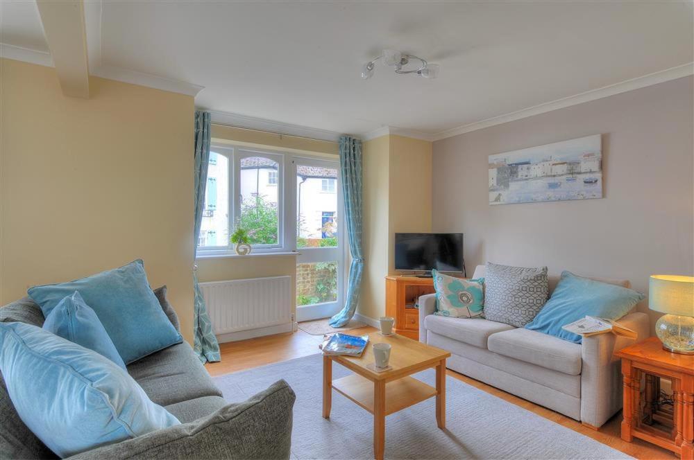 Una sala de estar con dos sofás y un televisor. en The Old Bakehouse, en Lyme Regis