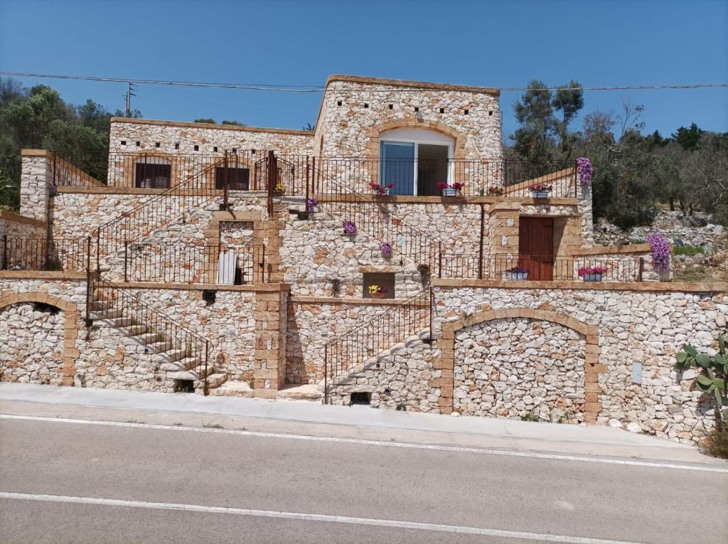 una casa de piedra al lado de una carretera en Villetta Cipolliane, en Marina di Leuca