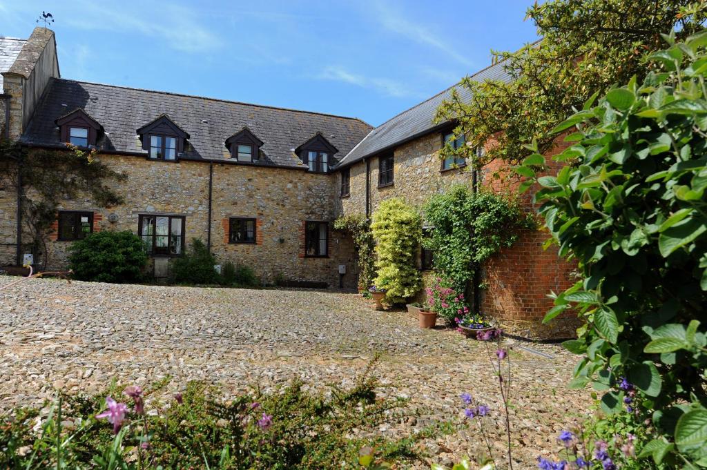 an external view of a building with a courtyard at Vine Cottage in Musbury