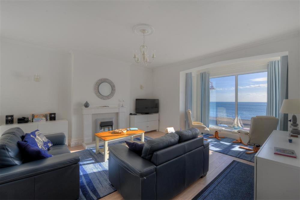 a living room with two couches and a fireplace and the ocean at 2 Mareeba in Seaton