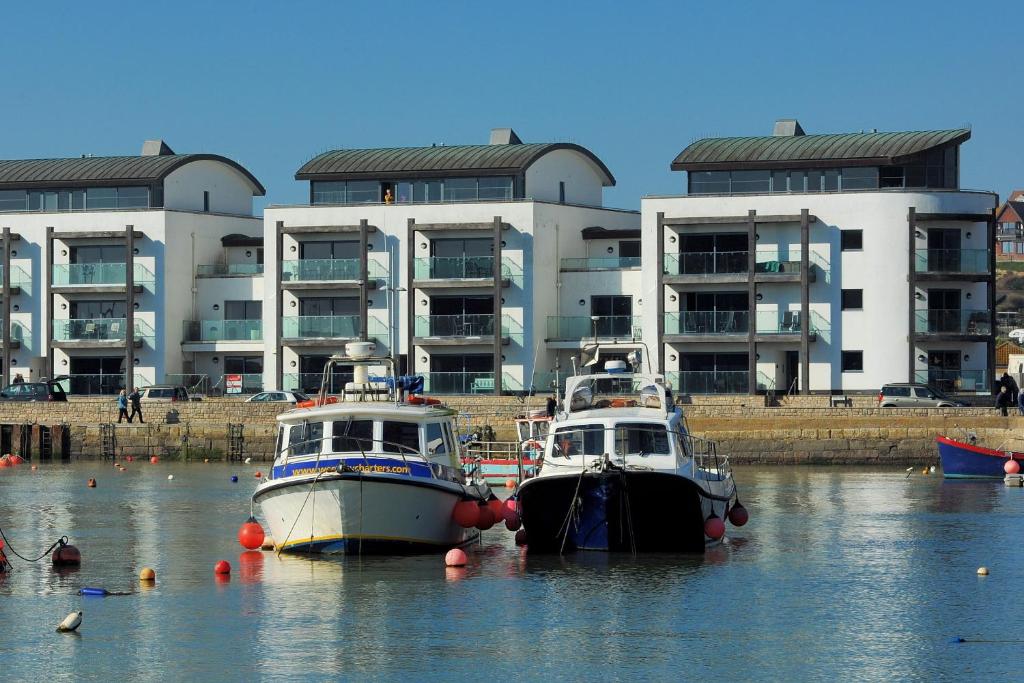 due barche in acqua di fronte a un edificio di Harbour View a West Bay