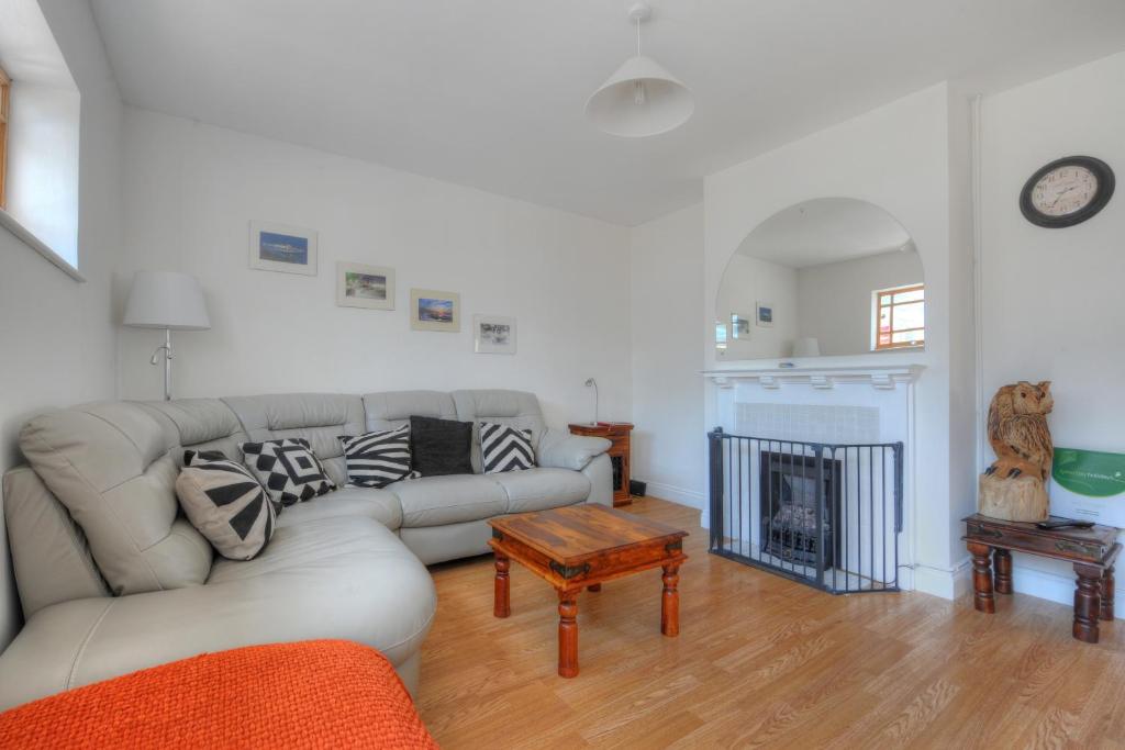 a living room with a couch and a fireplace at Little Ascot in Lyme Regis