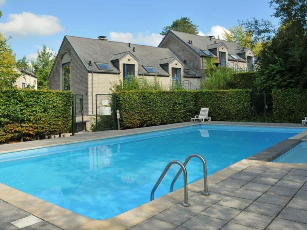 a swimming pool in front of a house at Enjoy Durbuy 5 in Durbuy