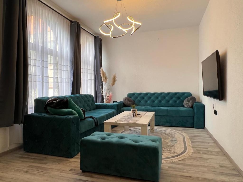 a living room with two green couches and a table at Guest House Eden in Bihać