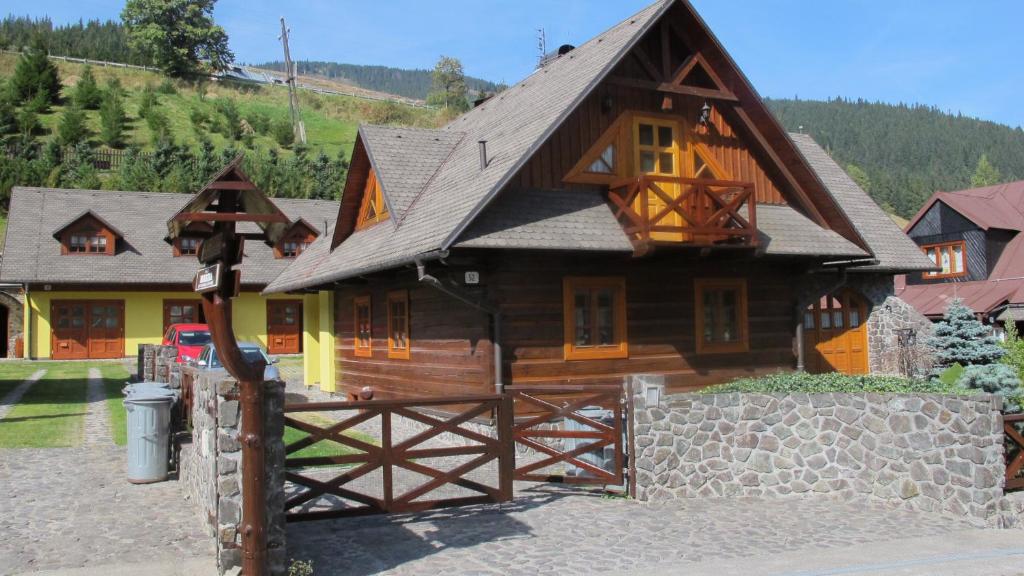 a large wooden house with a fence in front of it at Chaty Helena in Vyšná Boca