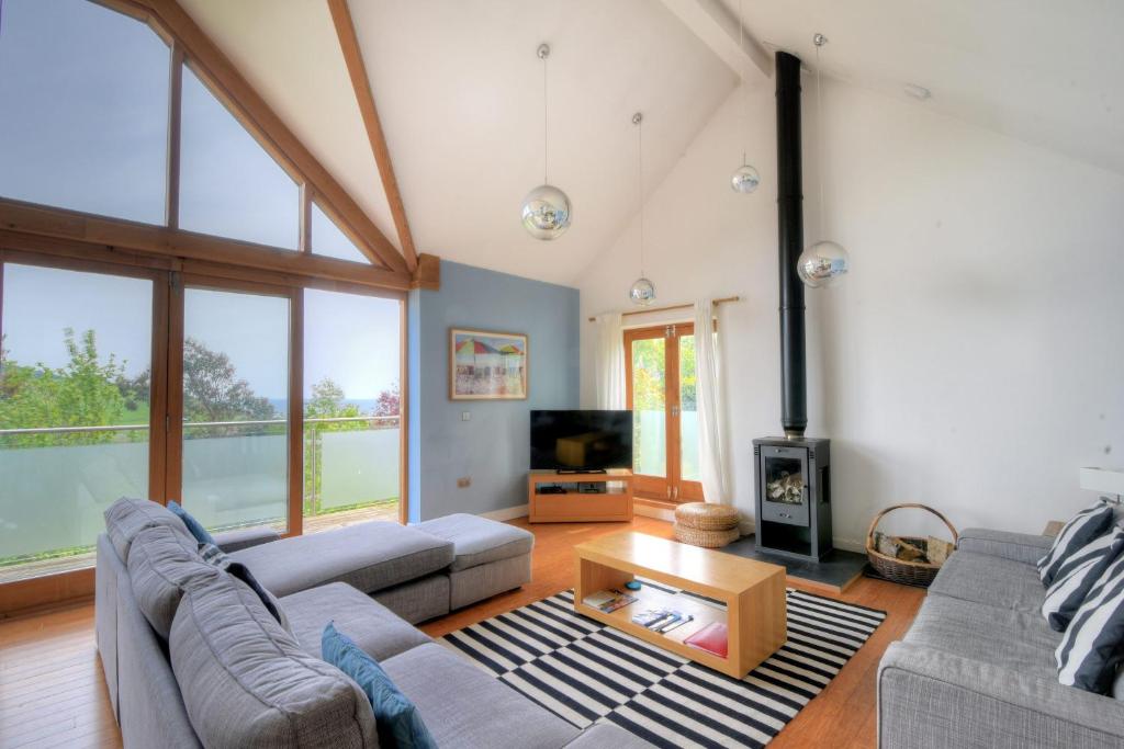 a living room with two couches and a fireplace at Pippin in Charmouth