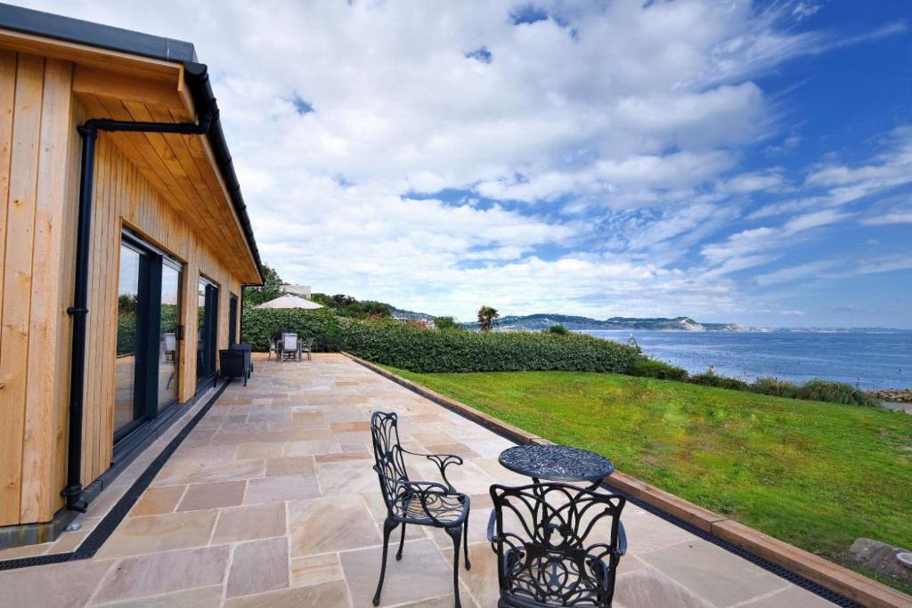 eine Terrasse mit 2 Stühlen und einem Tisch in der Unterkunft Harbour Heights Cottage in Lyme Regis