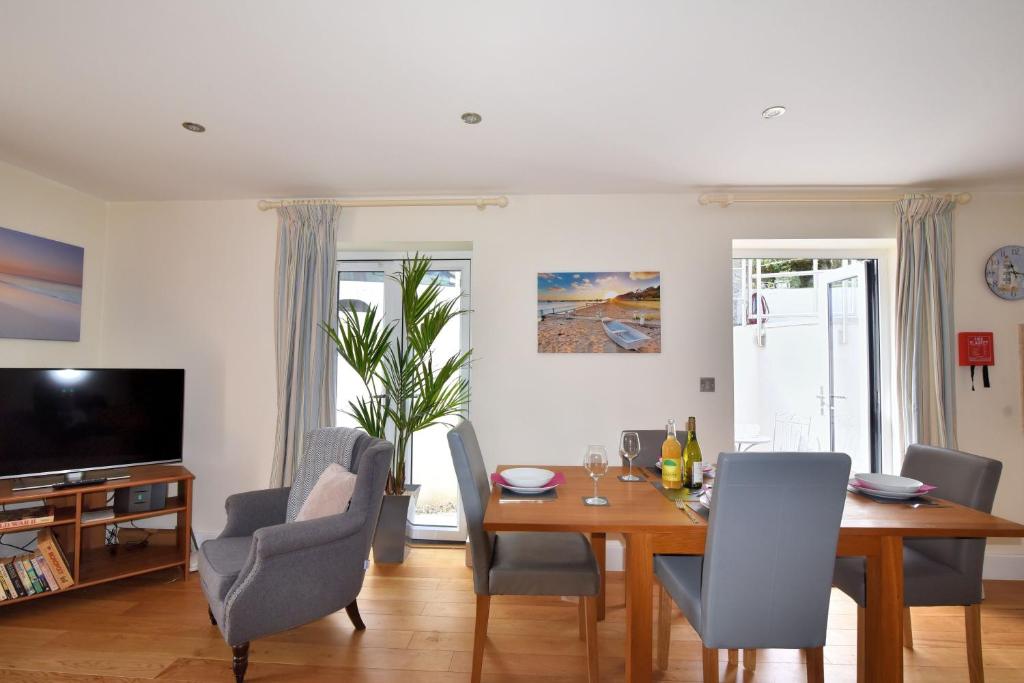 a living room with a dining room table and chairs at Seas The Day in Lyme Regis