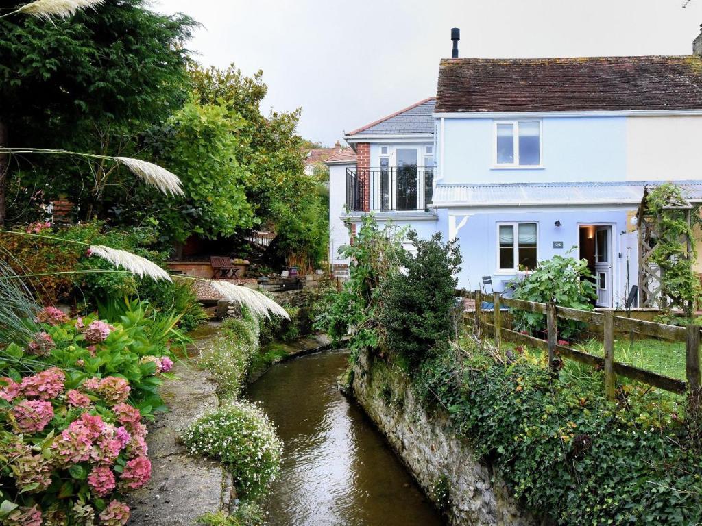 una casa y un río delante de una casa en 1 Lymbrook Cottages, en Lyme Regis