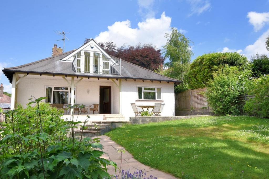 une petite maison blanche avec un jardin en face de celle-ci dans l'établissement Oak Tree, à Lyme Regis