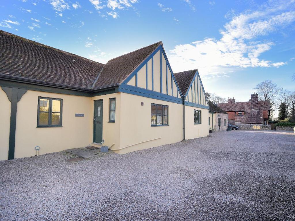 un edificio blanco con techo azul y entrada en 2 Home Farm South en Lyme Regis