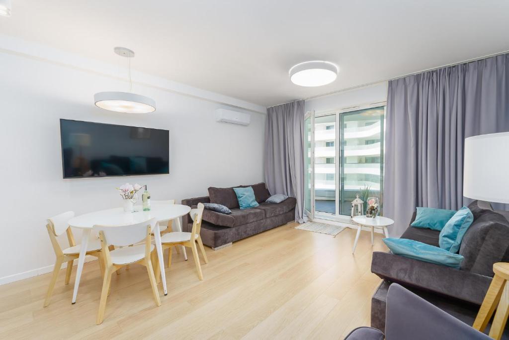 a living room with a table and a couch at Rogowo Pearl apartament Grace Bay in Rogowo