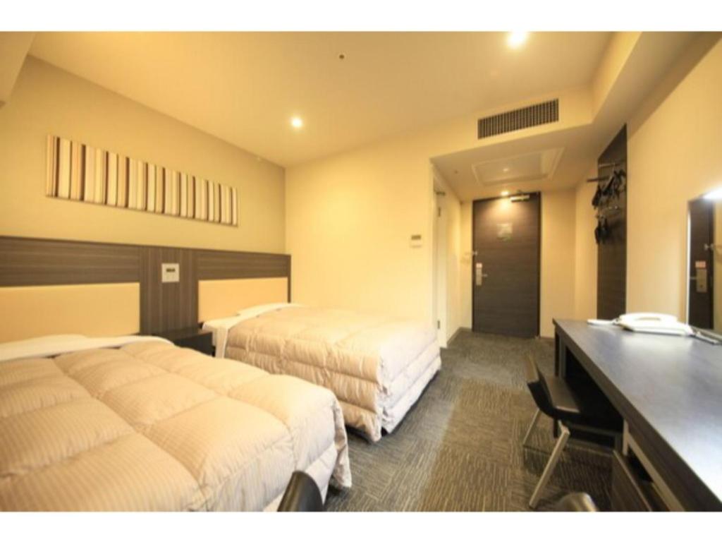 八王子市にあるR&B HOTEL HACHIOJI - Vacation STAY 38819vのベッド2台と机があるホテルの部屋