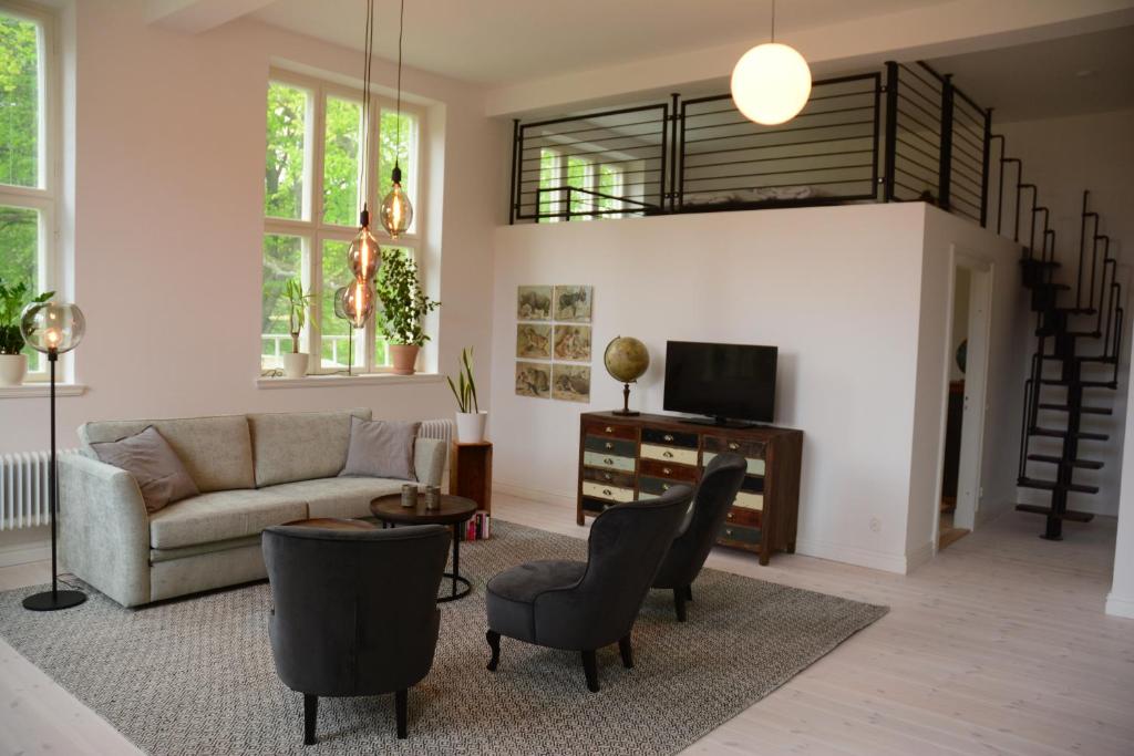 a living room with a couch and chairs and a tv at Grevlunda skola in Vitaby