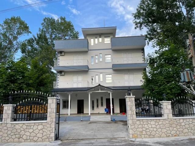a tall white building with a fence in front of it at Alexa Beach Apartment in Velipojë