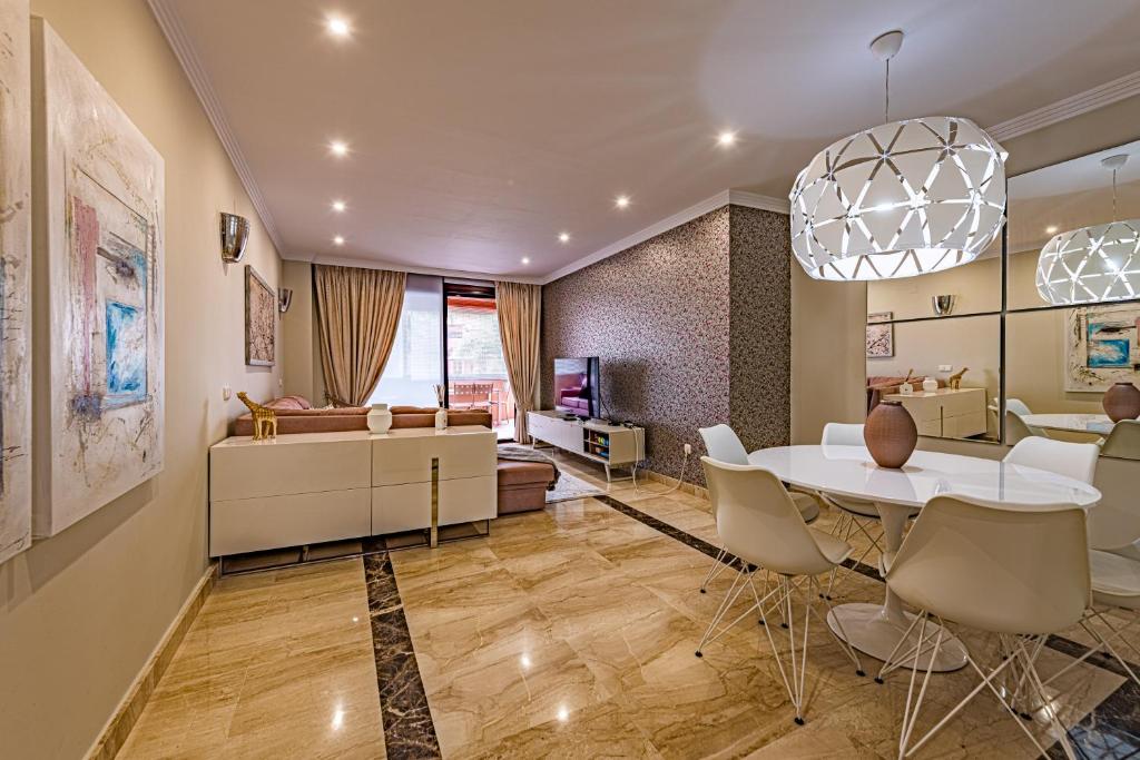 エステポナにあるMarina Luxury Apartmentのリビングルーム(テーブル、椅子、ソファ付)