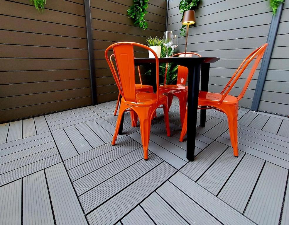 twee oranje stoelen en een tafel op een patio bij PETITE MAISON ELEGANTE MONOLOCALE CON TERRAZZA in Chiavari