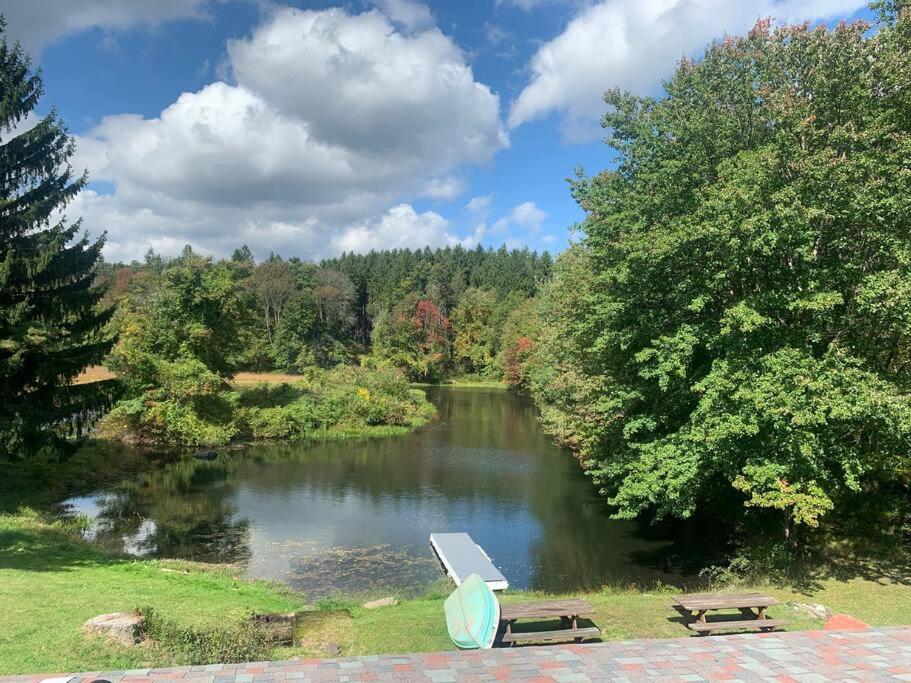 une table de pique-nique et un banc à côté d'une rivière dans l'établissement Spring Poconos Getaway! 2bd Cabin, à Henryville