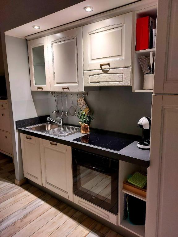 kuchnia z białymi szafkami i zlewem w obiekcie PETITE MAISON ELEGANTE MONOLOCALE CON TERRAZZA w mieście Chiavari