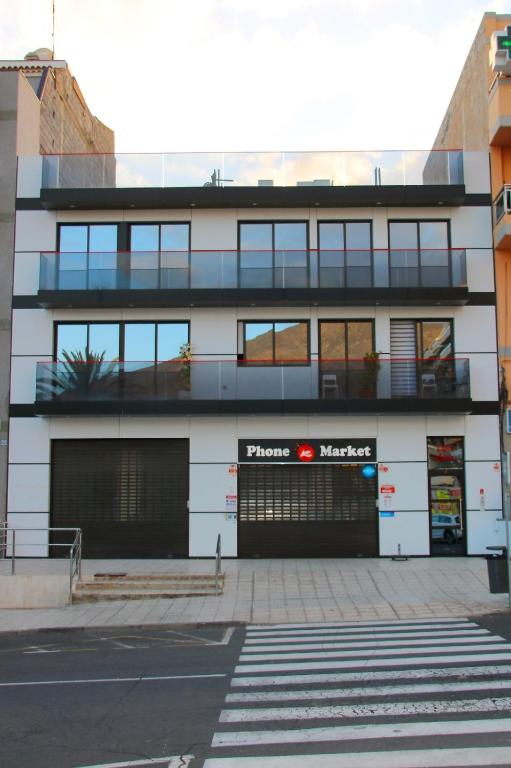 a building with a parking garage in front of it at Chajofe 8 in Los Cristianos
