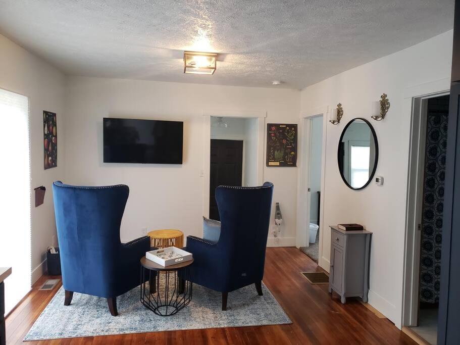 a living room with two blue chairs and a table at Cute Cottage-2 min from downtown Lincoln in Lincoln