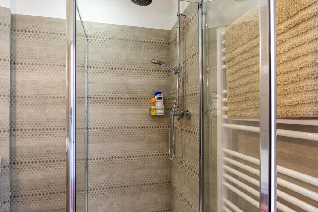 une douche avec une porte vitrée dans une salle de bain dans l'établissement appart cosy près gare, vieux port, MARSEILLE by Sam, à Marseille